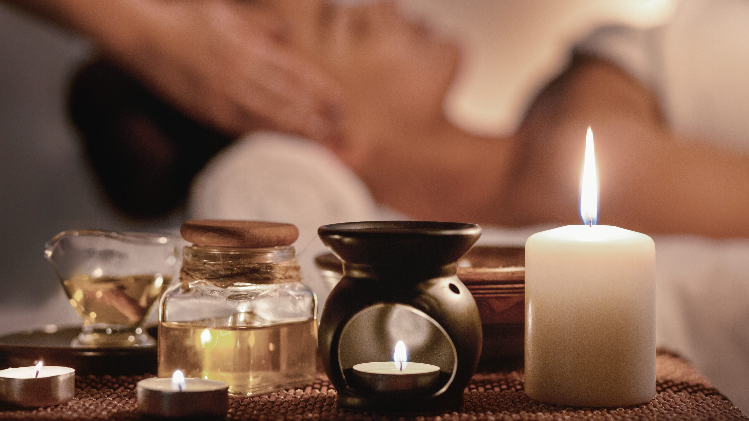 A serene spa setting with lit candles, aromatic oils, and a relaxing face massage, symbolizing tranquility and rejuvenation at Jivaka Spa, Kochi.